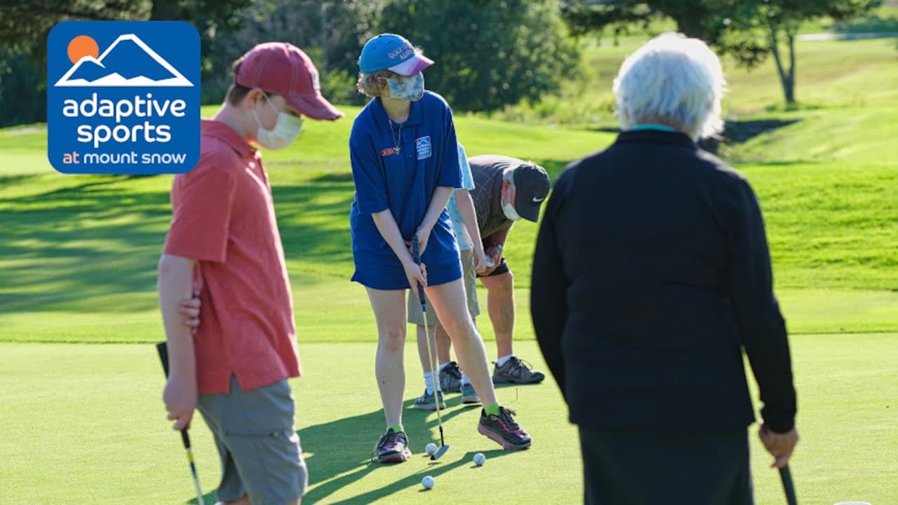 Adaptive students wearing masks practicing their putting skills with an instructor with his back to the camera.