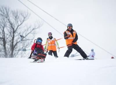 ASMS instructor and adaptive snowboarder posing together at Mount Snow